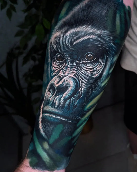 Big Black and Grey Gorilla with Leaves Tattoo on Men Arm by @glencarlosstattoo