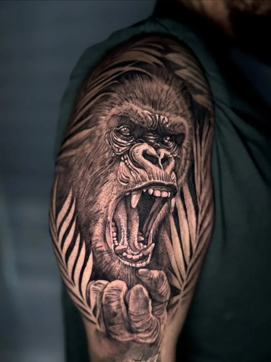 Big Black and Grey Gorilla with Palm Leaves Tattoo on Men Shoulder by @jokertattooinc