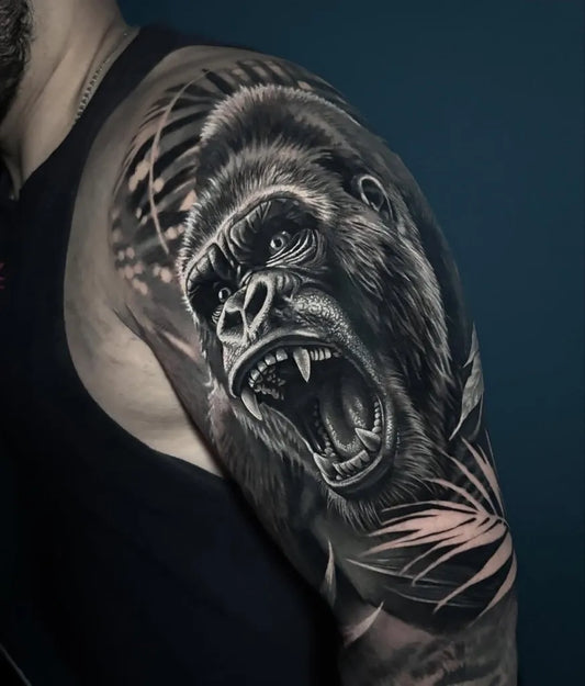 Big Black and Grey Gorilla with Palm Leaves Tattoo on Men Shoulder by @neonhearttattoo