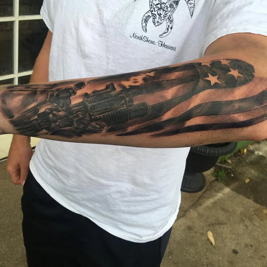 Big Black and Grey Gun and American Flag Military Tattoo on Men Arm by @chris_gilvarry