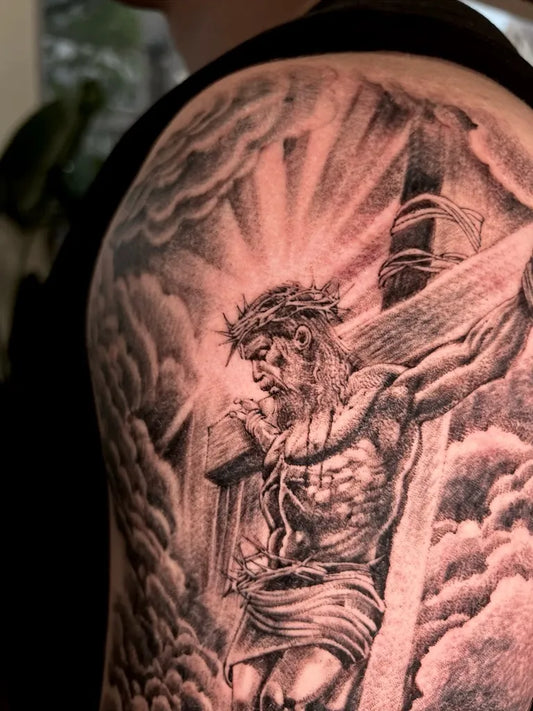 Big Black and Grey Jesus on Cross with Clouds Tattoo on Men Shoulder by @dongxi_tattoo
