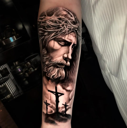 Big Black and Grey Jesus with Crosses Tattoo on Men Arm by @eceyesilcimen_tattooer