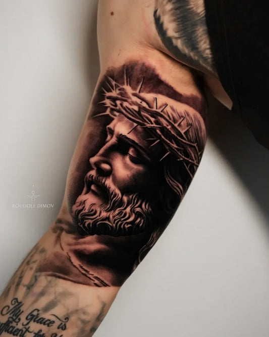 Big Black and Grey Jesus with Crown of Thorns Tattoo on Men Arm by @roudolfdimovtattoos