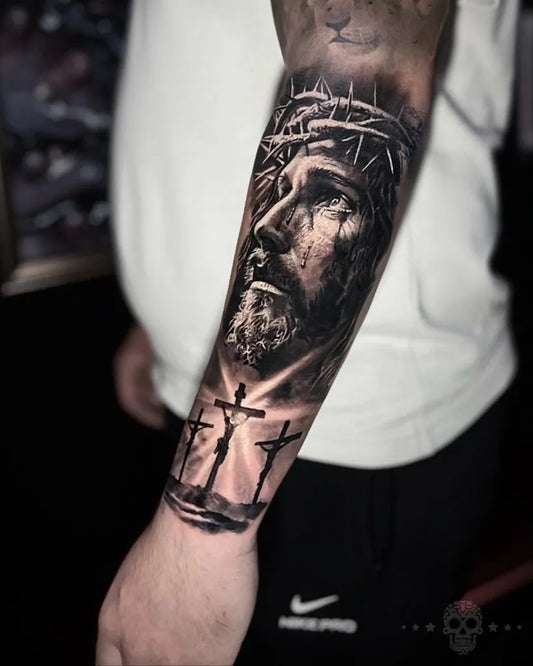 Big Black and Grey Jesus with Crown of Thorns and Crosses Tattoo on Men Arm by @crafttattoomaidstone
