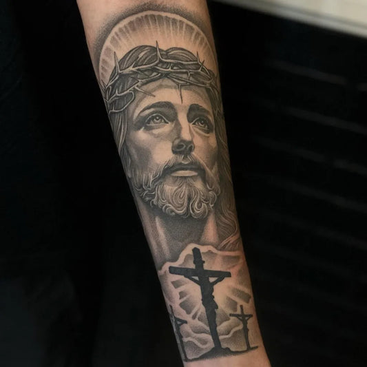 Big Black and Grey Jesus with Crown of Thorns and Crosses Tattoo on Men Arm by @outsyyde.tattoo