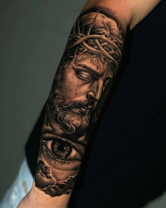 Big Black and Grey Jesus with Crown of Thorns and Eye Tattoo on Men Arm by @agmathiass.tattoo