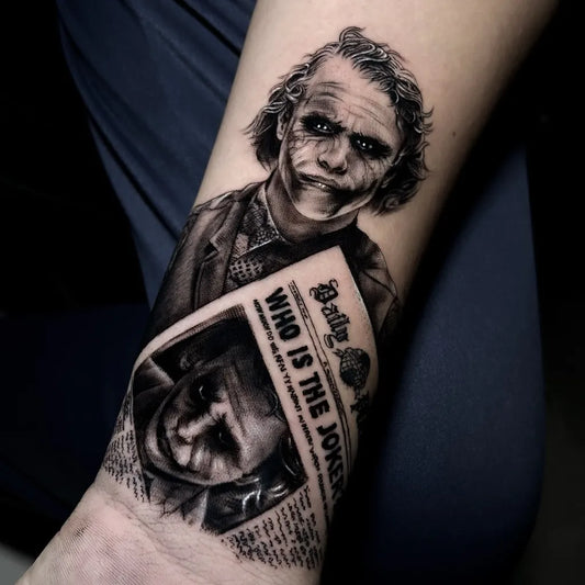 Big Black and Grey Joker Newspaper on Men Arm Tattoo by @jansenalmeidatattoo