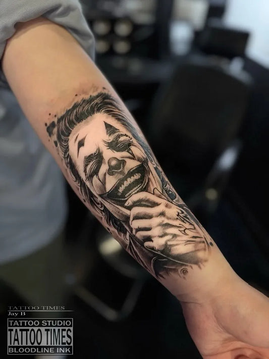Big Black and Grey Joker Portrait on Men Arm Tattoo by @tattoo.times