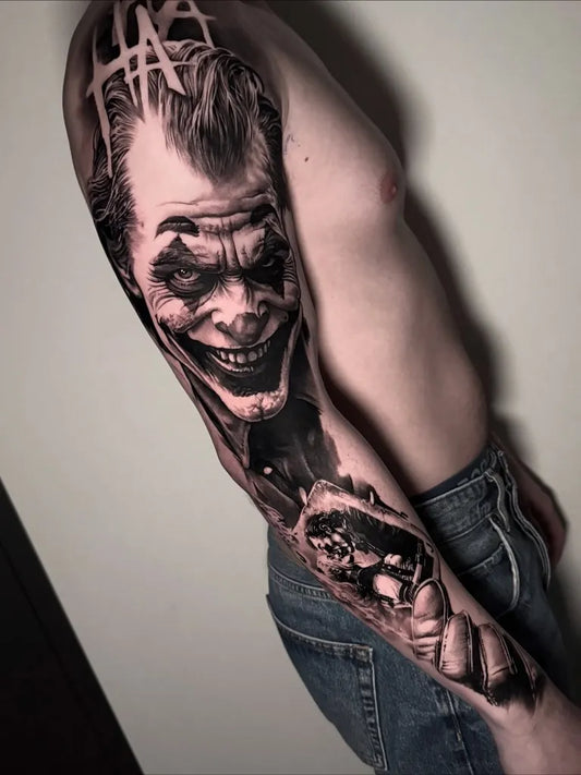 Big Black and Grey Joker portrait with skull and roses on Men Arm Tattoo by @michellev_tattoo