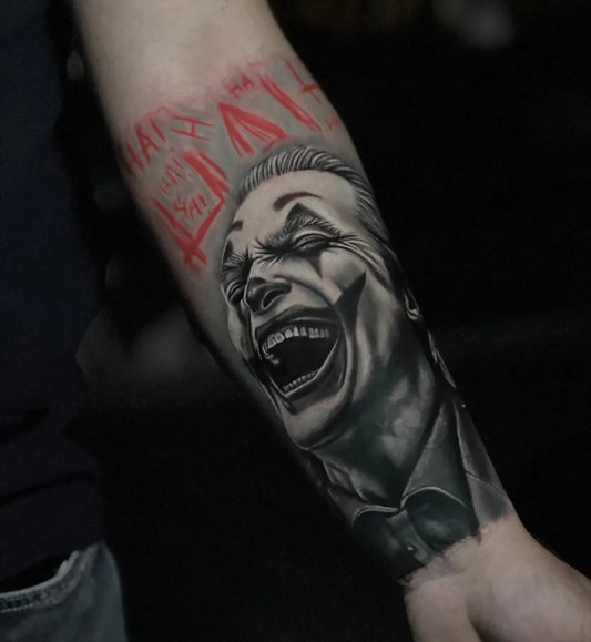 Big Black and Grey Joker with HaHa Text on Men Arm Tattoo by @solpantattoo.ink