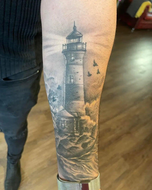 Big Black and Grey Lighthouse with Birds and Waves Tattoo on Men Arm by @gentle_steve_tattoos