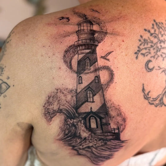 Big Black and Grey Lighthouse with Birds and Waves Tattoo on Men Shoulder by @blondi._ink