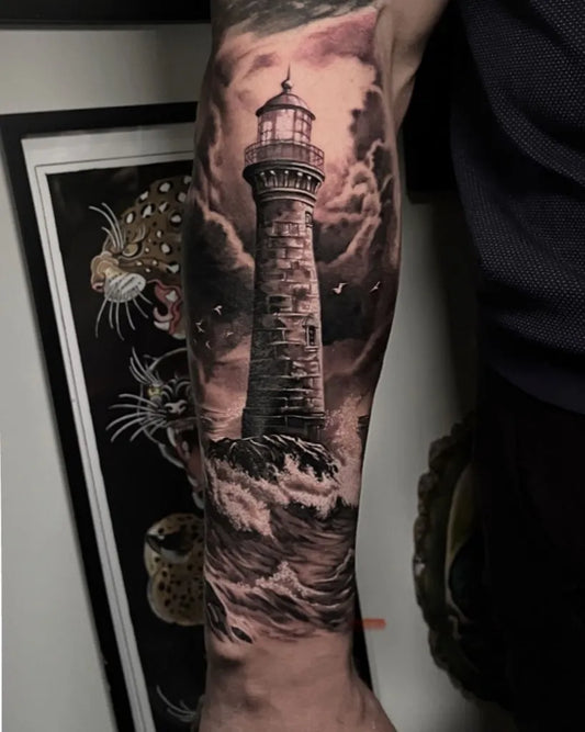 Big Black and Grey Lighthouse with Stormy Sea Tattoo on Men Arm by @bluedragontattoos345
