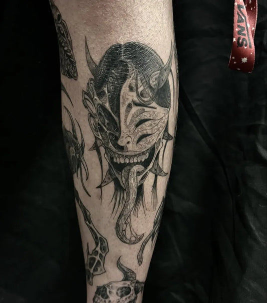 Big Black and Grey Oni Mask with Demon Horns and Tongue on Men Leg Tattoo by @toukyo_
