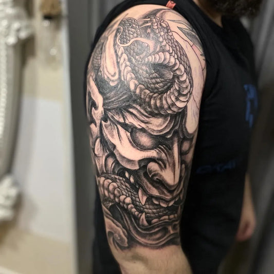 Big Black and Grey Oni Mask with Snake on Men Arm Tattoo by @cabracega_tattoostudio