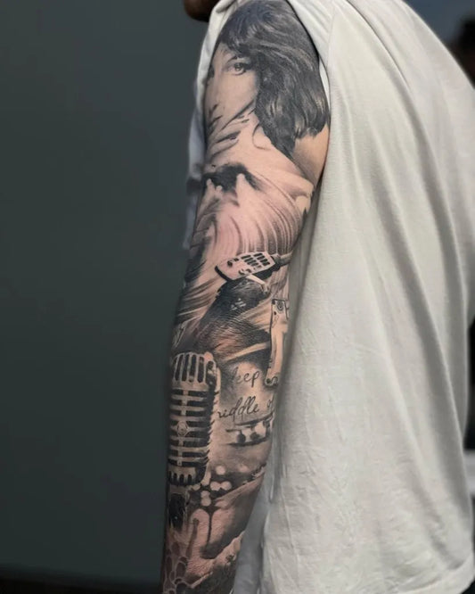 Big Black and Grey Portrait and Microphone Music Tattoo on Men Arm by @hugoink_bristol