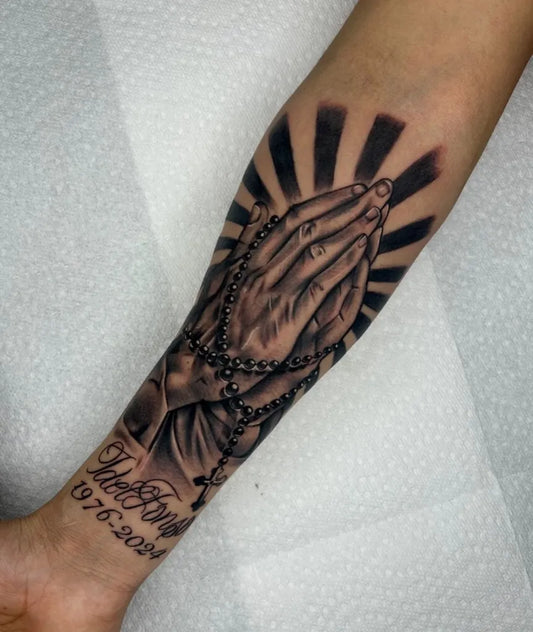 Big Black and Grey Praying Hands with Rosary and Sunburst Tattoo on Men Arm by @jhonnye_tattoo