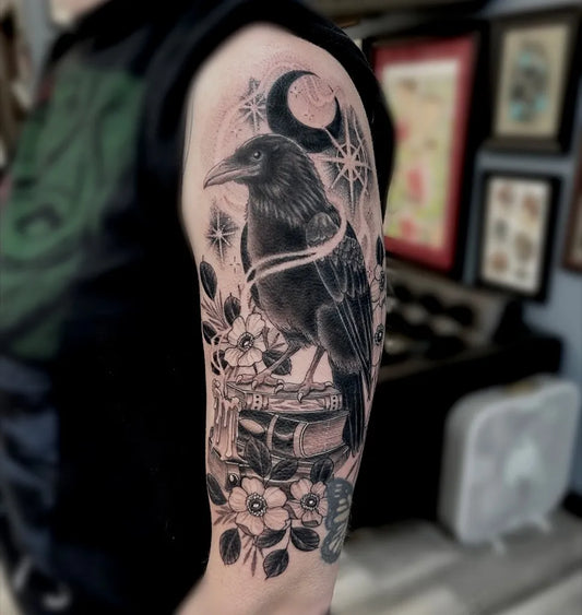Big Black and Grey Raven on Bookshelf on Men Arm Tattoo by @kaitland_tattoos