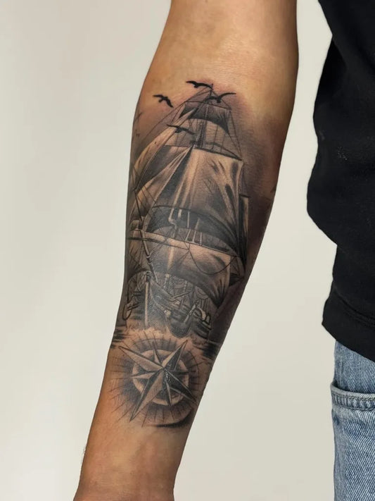 Big Black and Grey Sailing Ship and Compass on Men Arm Tattoo by @tattoogarden.aarau