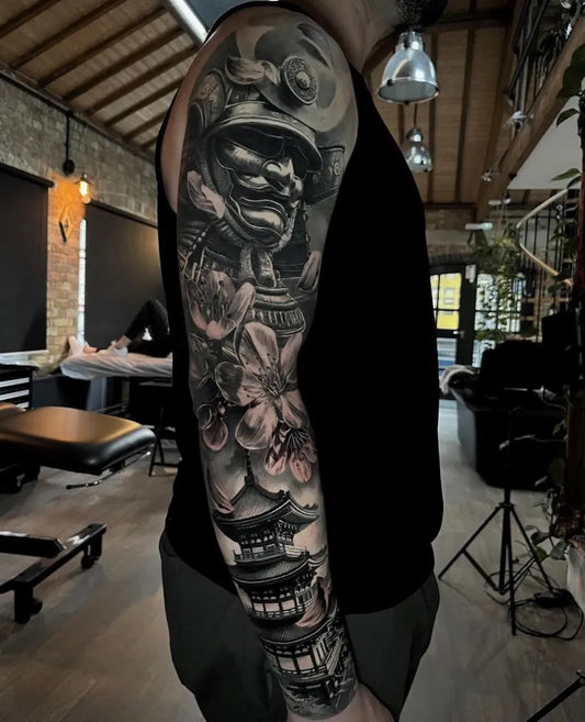 Big Black and Grey Samurai with Cherry Blossom and Pagoda Tattoo on Men Arm by @noireinkcollective