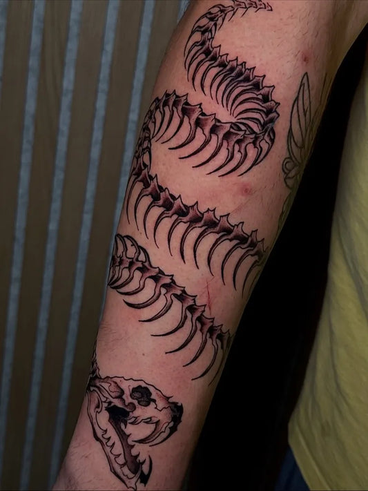 Big Black and Grey Skeleton Snake Tattoo on Men Arm by @m.inkks