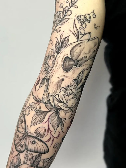 Big Black and Grey Skull Flower Butterfly Tattoo on Women Inner Arm by @libbynixtattoo