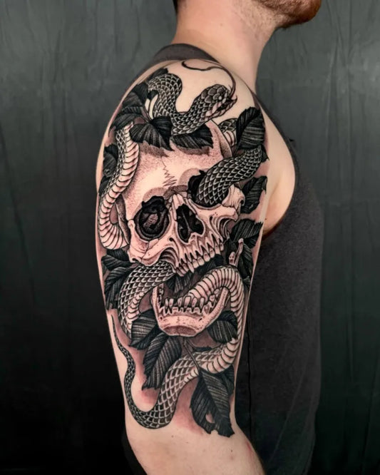 Big Black and Grey Skull and Snakes Tattoo on Men Upper Arm by @lamanigancetattootoronto
