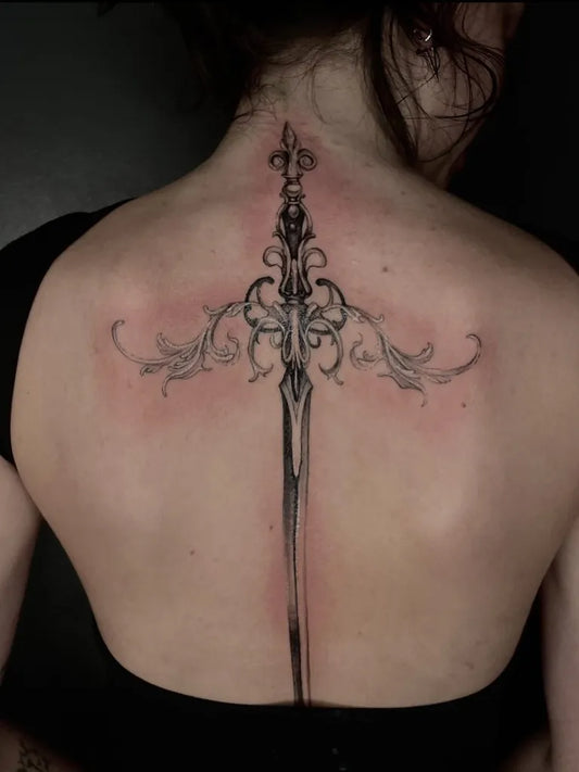 Big Black and Grey Sword with Ornate Hilt on Women Back Tattoo by @rr.annalise