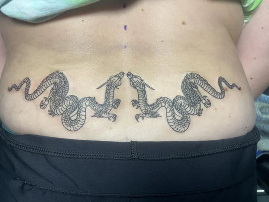 Big Black and Grey Twin Dragons Tattoo on Women Lower Back by @epicink_edwardsville