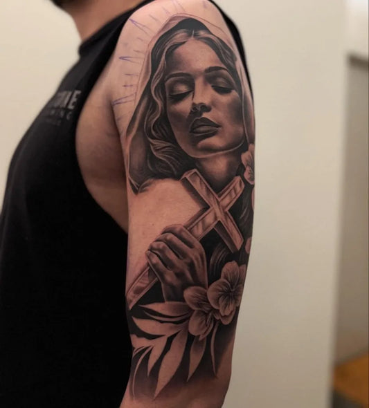 Big Black and Grey Virgin Mary with Cross and Flowers Tattoo on Men Arm by @dame.arte