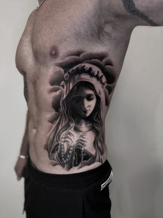 Big Black and Grey Virgin Mary with Rosary and Clouds Tattoo on Men Rib by @rhyanog.tattoo