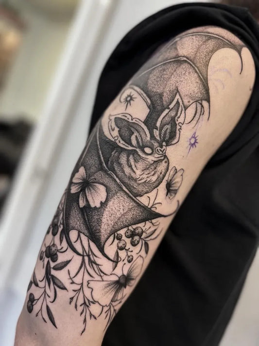 Big Blackwork Bat with Flowers Tattoo on Women Arm by @littleferntattoo