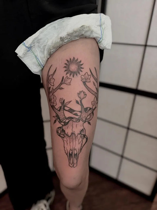 Big Blackwork Deer Skull with Sun and Flowers Tattoo on Women Thigh by @foxtrotttattoo