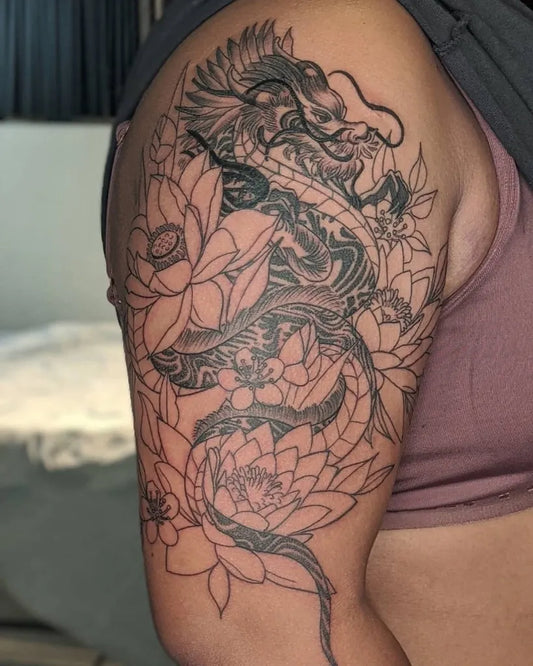 Big Blackwork Dragon and Lotus Tattoo on Women Bicep by @tritontattoosantacruz