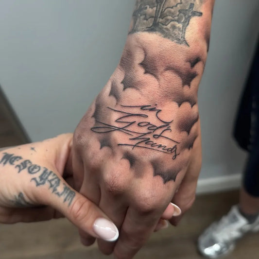Big Blackwork In God We Trust Script Cloud Pattern on Men Hand Tattoo by @1995tattoo.zurich