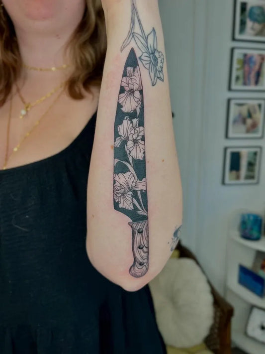 Big Blackwork Knife with Flowers Tattoo on Women Arm by @tay.leigh.k