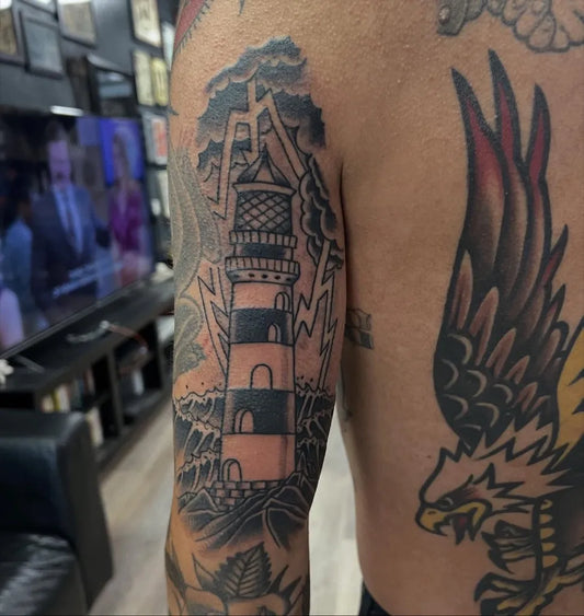 Big Blackwork Lighthouse with Eagle and Waves Tattoo on Men Arm by @kanetattoos