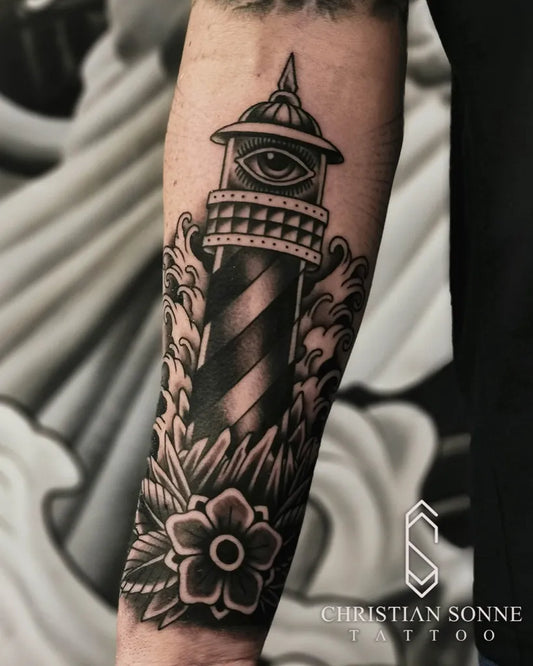 Big Blackwork Lighthouse with Waves and Flower Tattoo on Men Arm by @christiansonnetattoo