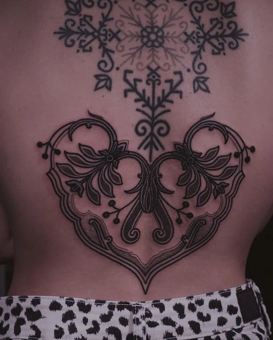 Big Blackwork Ornate Heart and Snowflakes Tattoo on Women Lower Back by @serjiu.arnautu