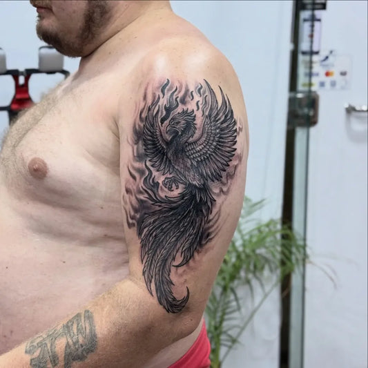 Big Blackwork Phoenix and Flames on Men Upper Arm Tattoo by @dr_g_tattoo_hurghada