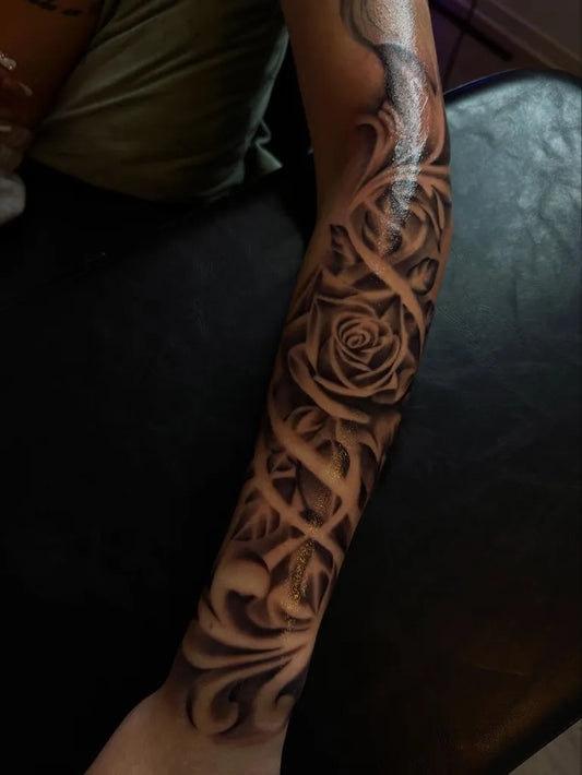 Big Blackwork Roses and Tribal on Women Arm Tattoo by @hazy.ink