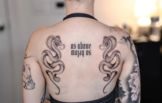 Big Blackwork Snakes and Text on Women Back Tattoo by @krisamber.tattoo