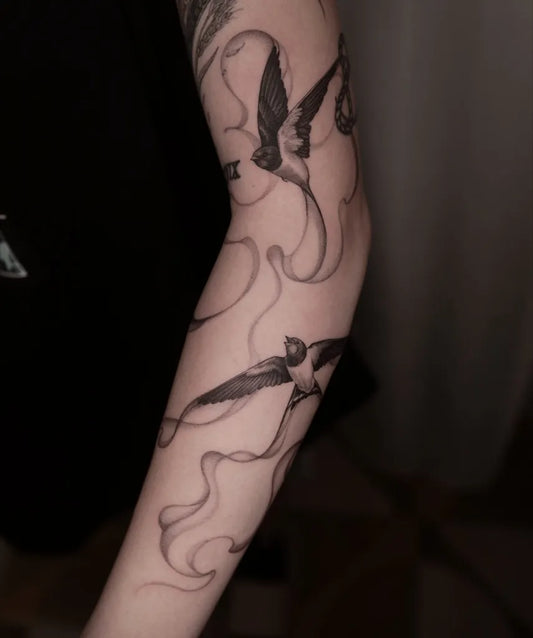 Big Blackwork Swallow and Smoke Tattoo on Women Arm by @rensu_tattoo