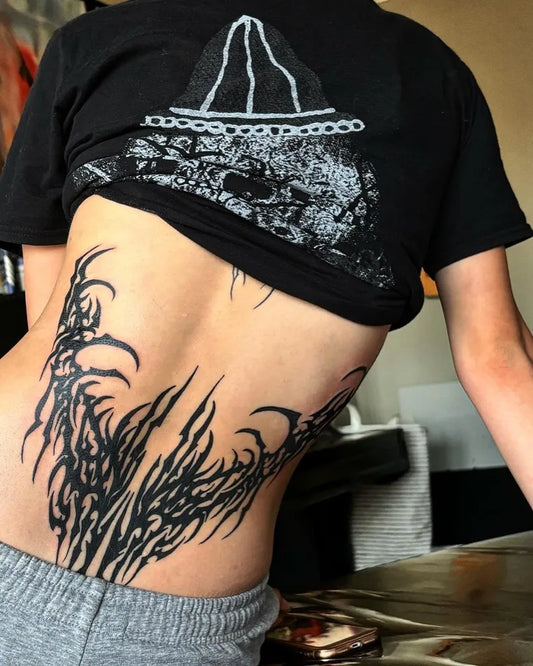 Big Blackwork Tribal Backbone Tattoo on Women Lower Back by @shibektats