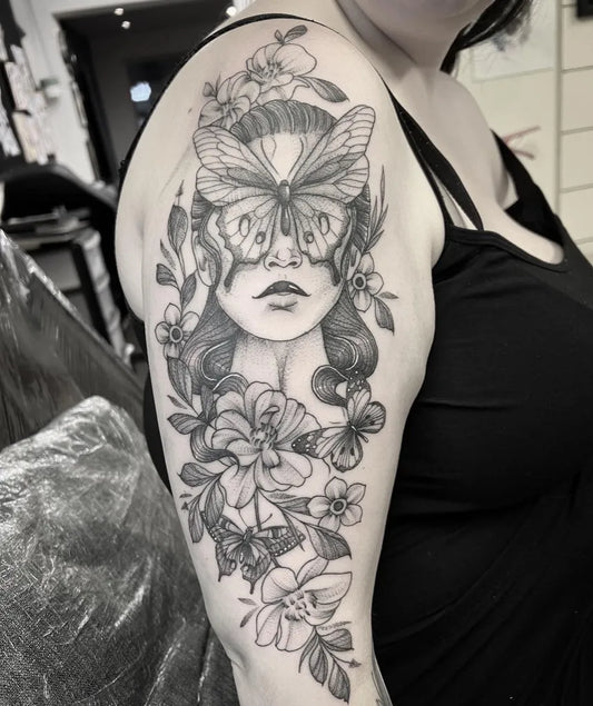 Big Blackwork Woman with Butterfly Mask and Flowers Tattoo on Women Bicep by @roogladwelltattoos