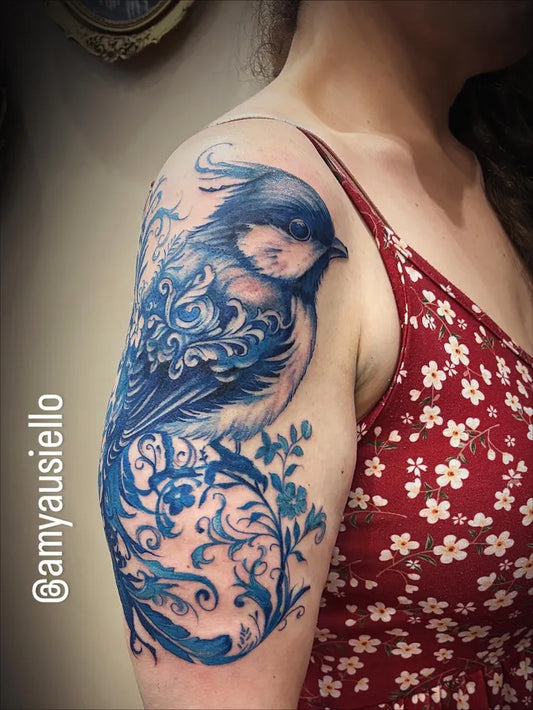 Big Blue Bird with Floral Vines Tattoo on Women Shoulder by @thepittsburghtattoostudio