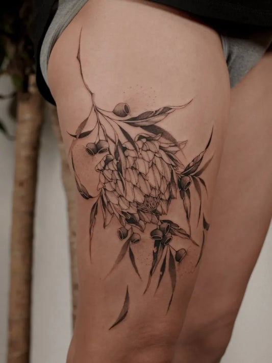 Big Botanical Waratah and Eucalyptus on Women Thigh Tattoo by @swink.inc