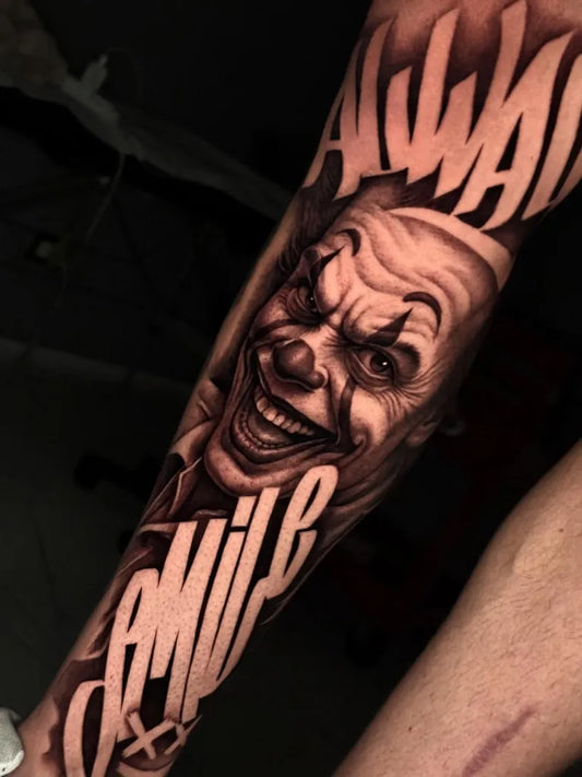 Big Chicano Smiling Clown with Smile Text Tattoo on Men Arm by @lorenzo_pascuccii
