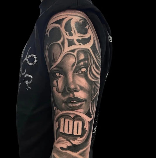 Big Chicano Woman with floral elements and 100 Tattoo on Men Arm by @oceaninktattoos