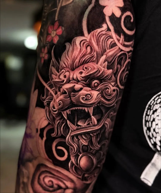 Big Chinese Foo Dog With Flowers Tattoo on Men Arm by @yazminvillatattoo